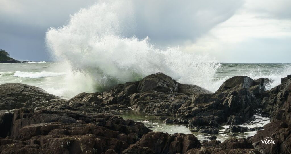 Large waves crashing on the rocky shoreline of Tofino. Storm watching in Tofino is a spectacular winter activity.